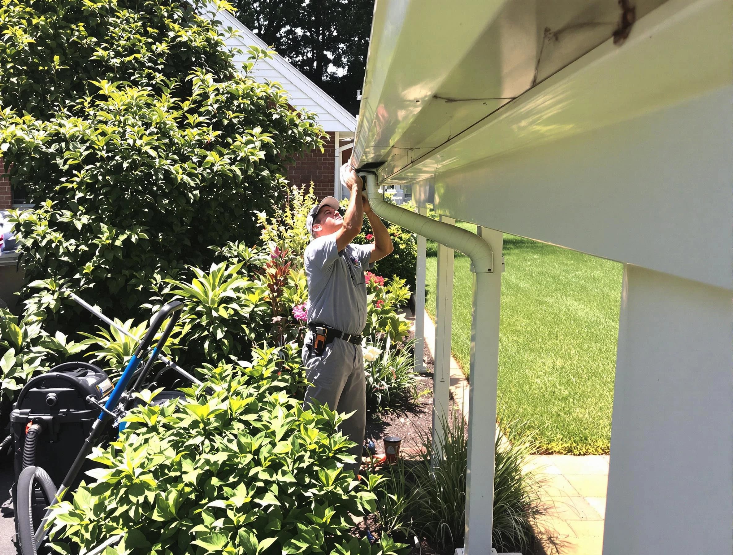 Technician flushing a blockage from a downspout in Cleveland, OH